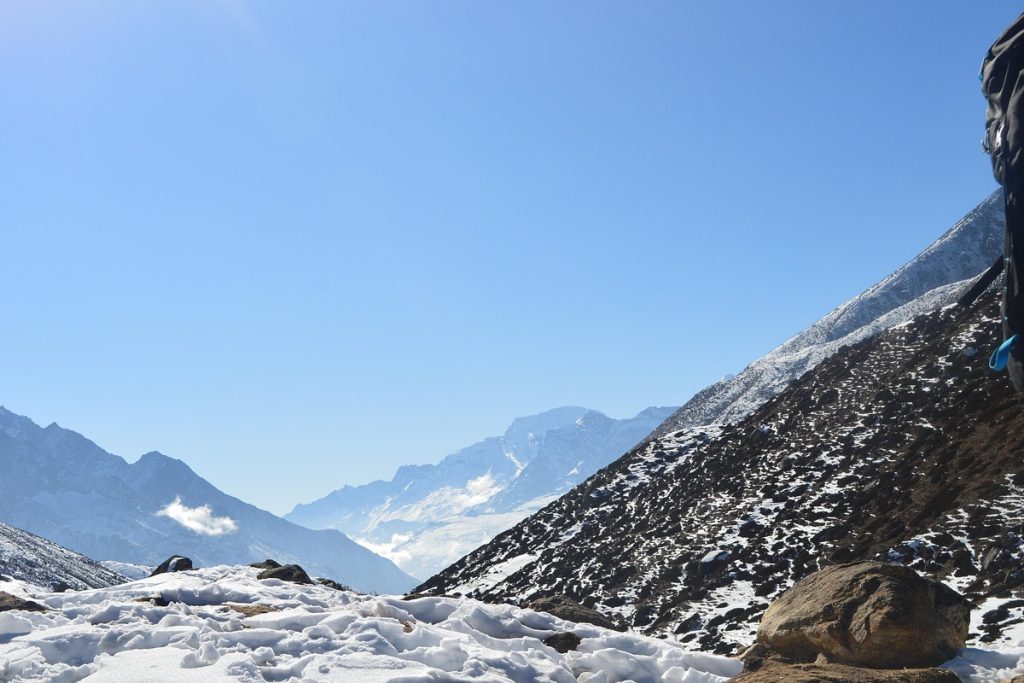 Panoramic view of Mount Everest at sunrise, with golden light illuminating snow-covered peaks in the Himalayas.
