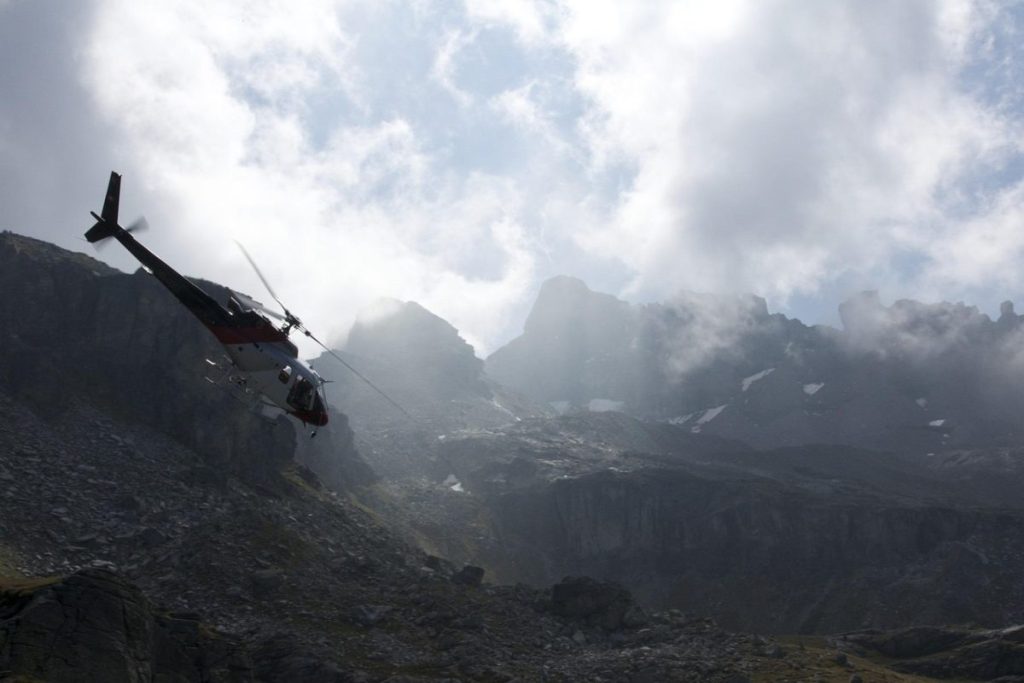 Helicopter flying above Everest region with mountain range and blue sky in background